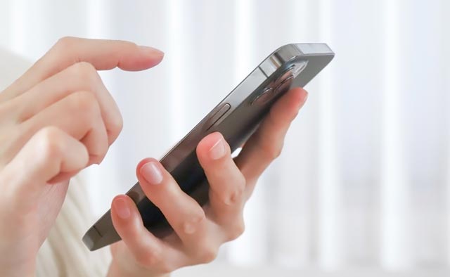 家族葬の日野市葬儀社に電話でお問合せしようとしている人の手元。